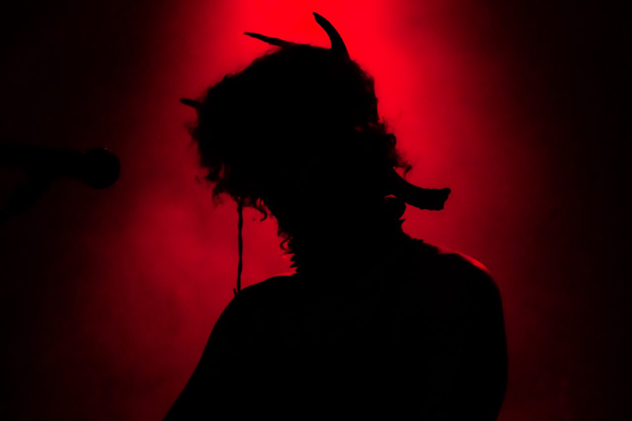 A silhouette against red light, hair flying.