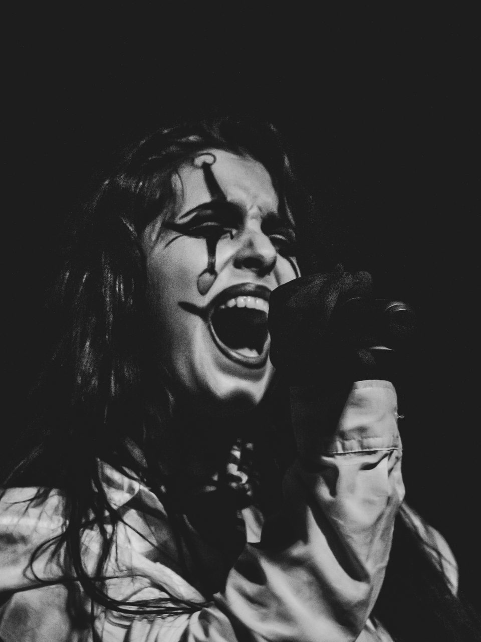 Sharone screaming, jester paint across her face.