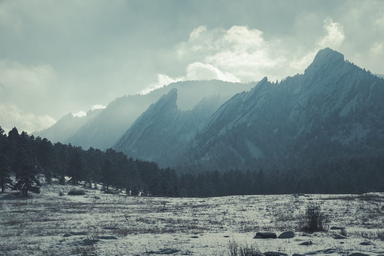 Snow peaks above a pale meadow.