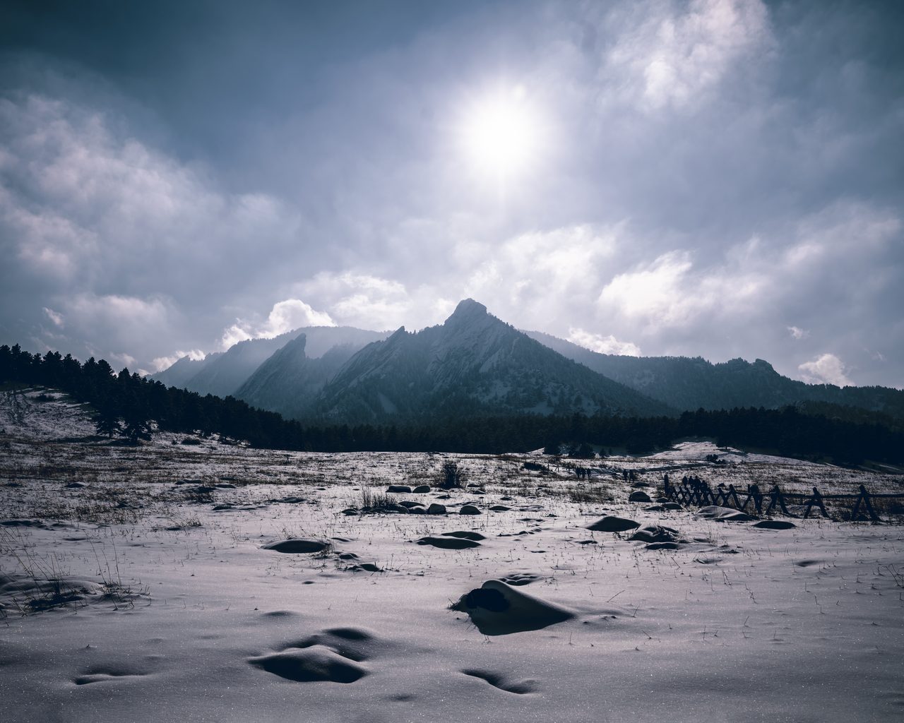A moonlit snowfield below a peak.